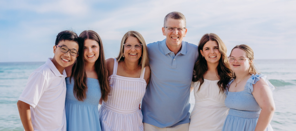 A family supporting their child with special needs enjoying time together on the beach