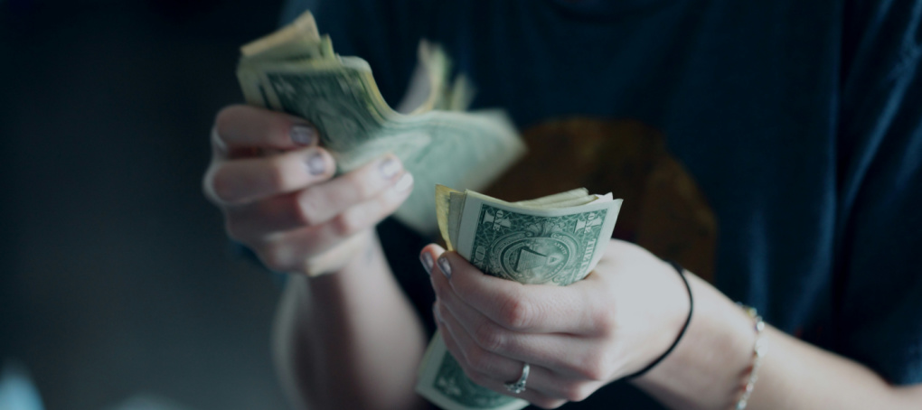 Image of someone counting dollar bills